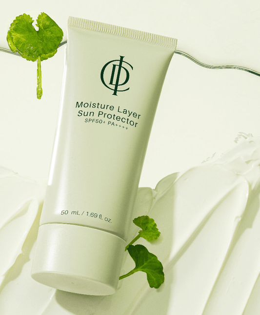 Riman ICD Moisture Layer Sunscreen in a tube with SPF 50+ and hydration benefits on a green background.