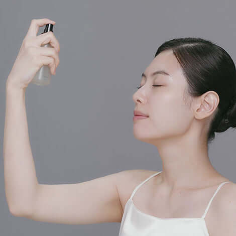 Woman applying Riman Incellderm Vieton Oil Mist for bright, dewy, and moisturized skin.