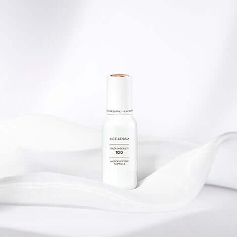 RADIANSOME 100 Microfluidizer Ampoule bottle on soft white fabric, showcasing a hydrating anti-aging formula.