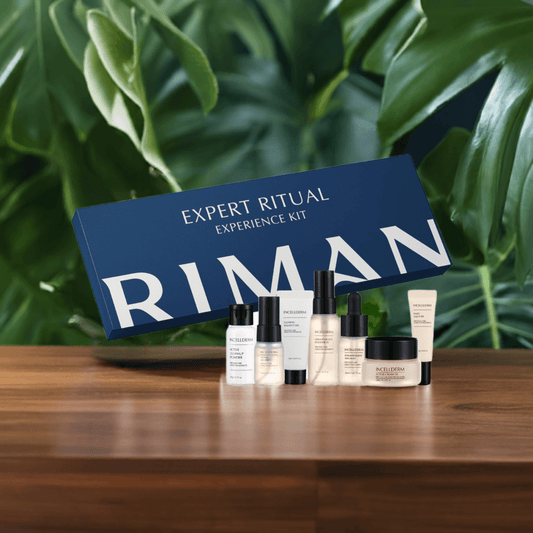 Riman Expert Ritual Experience Kit in a gift box with travel-sized skincare products on a wooden surface.