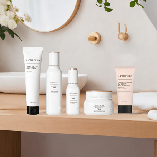 Incellderm skincare products displayed on a vanity, featuring cleanser, essence, serum, cream, and sunscreen.