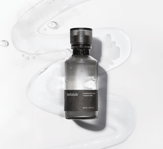 Riman Botalab Deserticola Plus Conditioner bottle on a wavy background with hydrating gel, perfect for hair care.