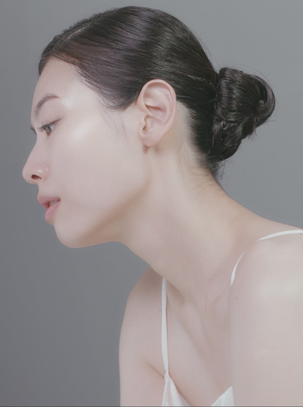 Profile view of a woman with glowing skin, showcasing radiance and healthy skin texture.