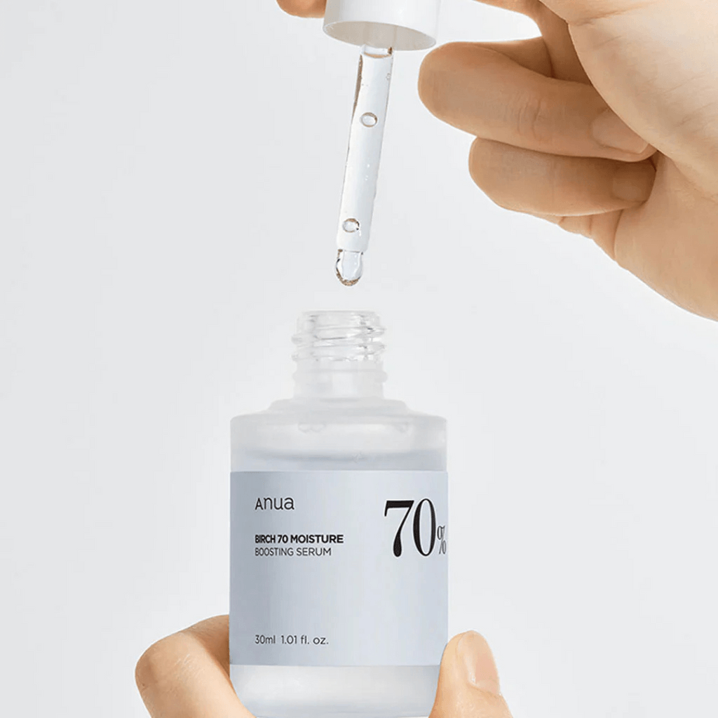 Anua Birch 70 Moisture Boosting Serum being dispensed from a dropper for skin hydration.