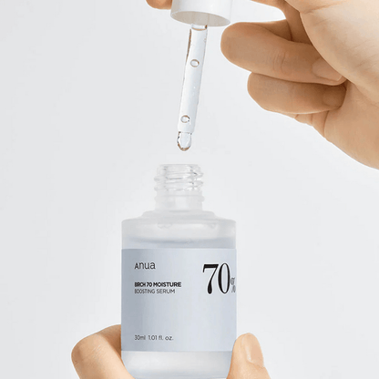 Anua Birch 70 Moisture Boosting Serum being dispensed from a dropper for skin hydration.