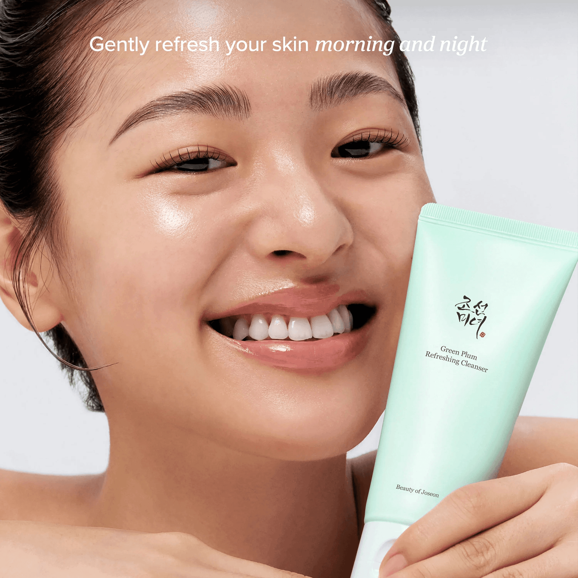 Beauty of Joseon Green Plum Refreshing Cleanser in the hands of a smiling person, promoting gentle skin refreshment.