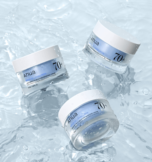 Three jars of Anua Birch 70 Moisture Boosting Cream on water surface, showcasing hydration and skincare benefits.