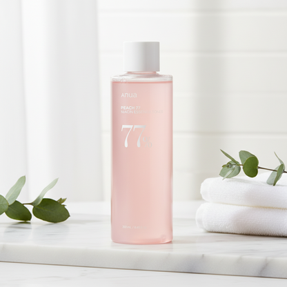 Anua Peach 77 Niacin Essence Toner in a pink bottle promoting hydration and glow for the skin.
