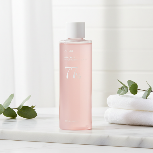Anua Peach 77 Niacin Essence Toner in a pink bottle promoting hydration and glow for the skin.