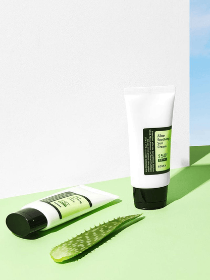COSRX Aloe Soothing Sun Cream SPF50 with aloe vera leaf on green surface, perfect for Korean skincare.