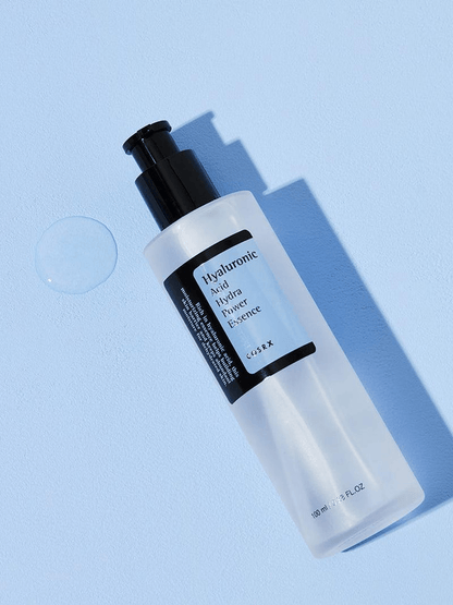 COSRX Hyaluronic Acid Hydra Power Essence bottle on a blue background, showcasing its hydrating properties.