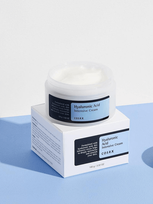COSRX Hyaluronic Acid Intensive Cream in jar and box packaging on blue surface with hydrating benefits highlighted.