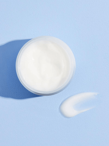 COSRX Hyaluronic Acid Intensive Cream in a clear jar with a dollop of cream beside it on a blue background.