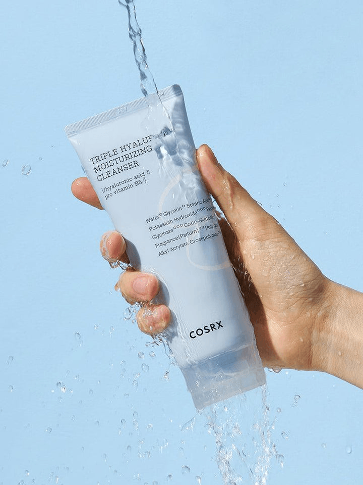 COSRX Triple Hyaluronic Moisturizing Cleanser in hand with water splash background