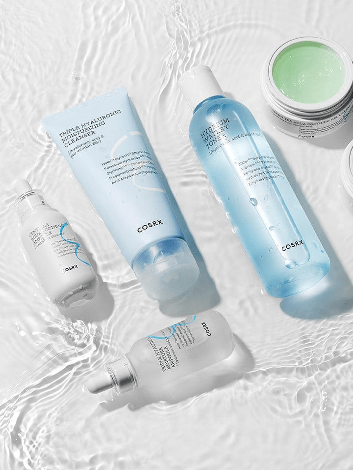 COSRX Triple Hyaluronic Moisturizing Cleanser products displayed on a wet surface, showcasing hydration and cleansing benefits.