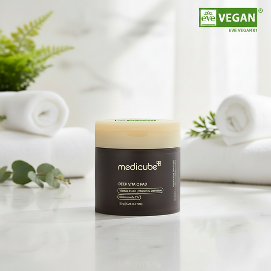 Medicube Deep Vita C Pads container surrounded by towels and greenery, promoting skincare benefits.