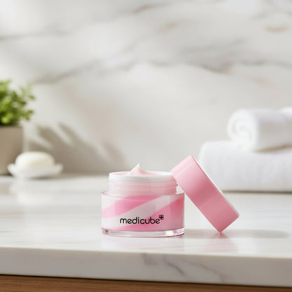 Medicube PDRN Lip Sleeping Mask in a jar with a pink lid on a marble countertop background.