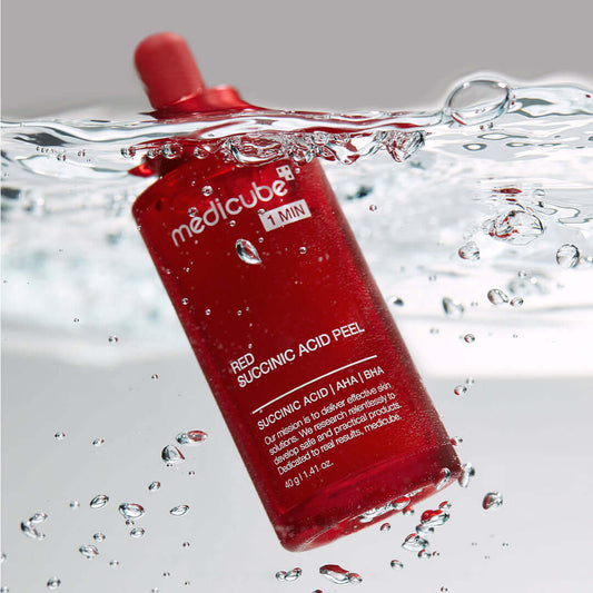 Medicube 21% Red Succinic Acid Cleansing Booster Serum in water, showcasing its exfoliating properties and vibrant red packaging.