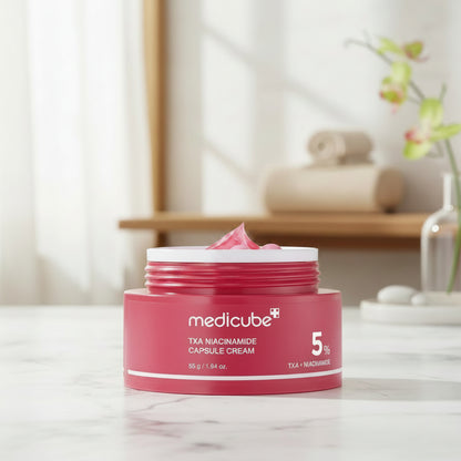 Red jar of Medicube TXA Niacinamide Capsule Cream with pink cream and capsules on a white background