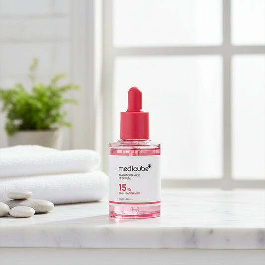 Medicube TXA Niacinamide Serum bottle on a table with towels and pebbles for skincare