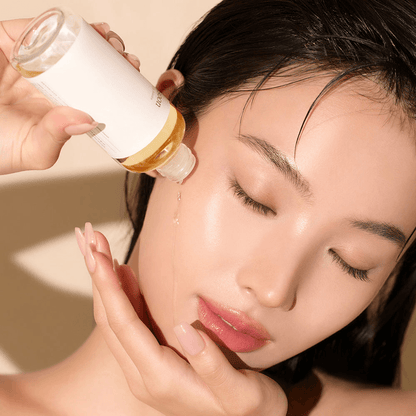 mixsoon Heartleaf Essence being applied to a model's face for a glowing Korean glass skin effect.